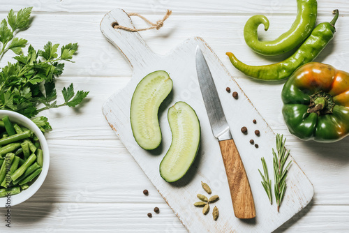 фотографія top view of cut cucumber on white wooden cutting board