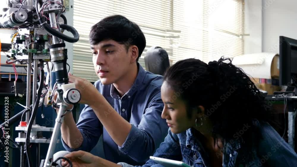 Engineering collaborating on develop of robot in laboratory together. 4K Resolution. Engineering collaborating on develop of robot in laboratory together. 4K Resolution.