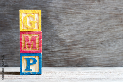 Color letter block in word GMP (Abbreviation of good manufacturing practice)  on wood background photo