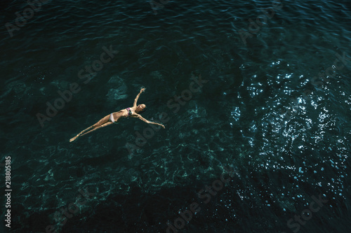 aerial view of a woman floating and reraxing in the sea