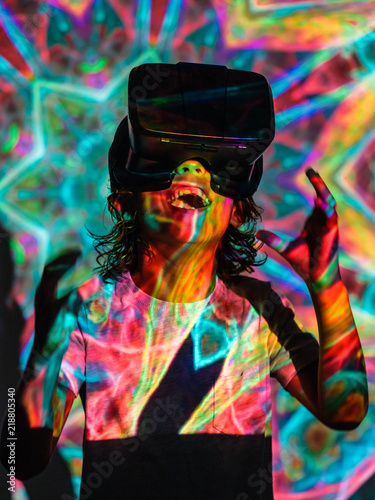 Bright projection on excited boy in VR headset photo