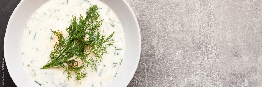 Panoramic photo of concrete copy space worktop with cold cucumber soup with dill seen from above Panoramic photo of concrete copy space worktop with cold cucumber soup with dill seen from above