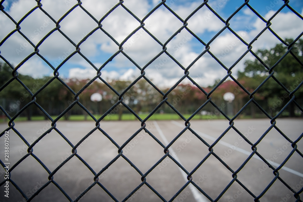 Fototapeta premium Outdoor basketball Court through Fence 