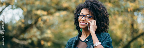 Happy black woman during a mobile phone call in autumn photo
