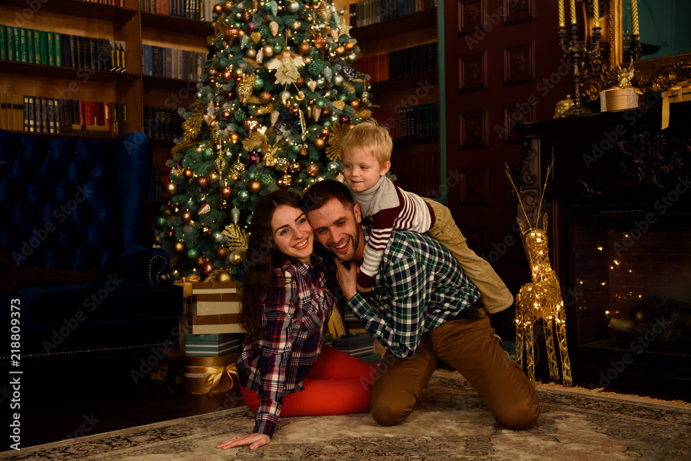 happy family mother father and baby at christmas tree at home