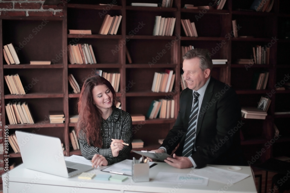 businessman and assistant discussing a working paper businessman and assistant discussing a working paper