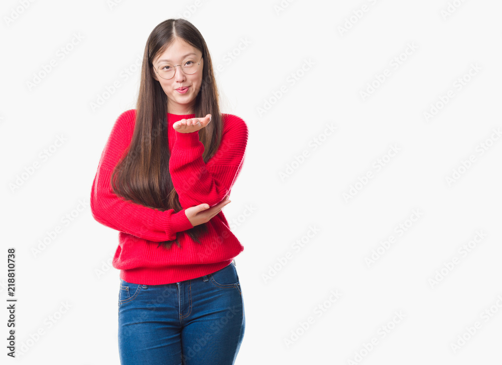 Young Chinese woman over isolated background wearing glasses looking at the camera blowing a kiss with hand on air being lovely and sexy. Love expression. Young Chinese woman over isolated background wearing glasses looking at the camera blowing a kiss with hand on air being lovely and sexy. Love expression.