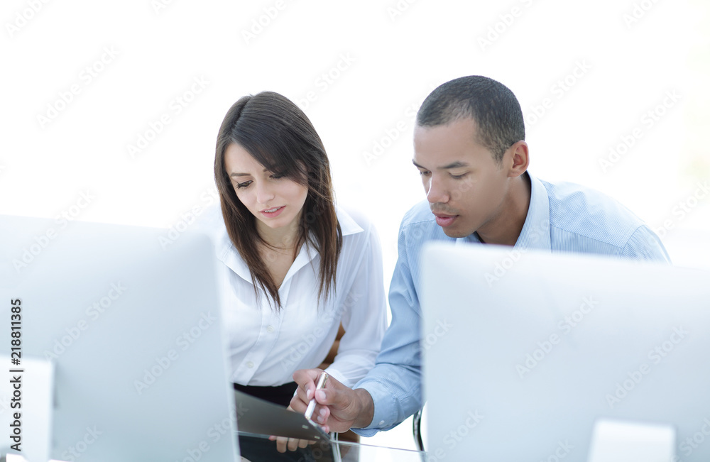 employees discussing financial documents sitting at a Desk employees discussing financial documents sitting at a Desk