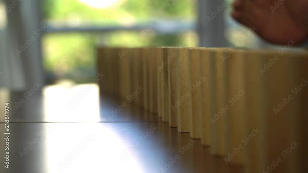 Wooden blocks falling in line domino effect business concept