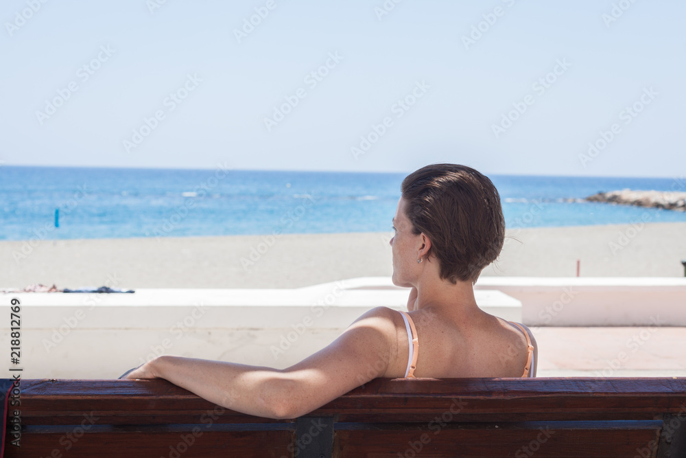 Young woman phone on beach bench