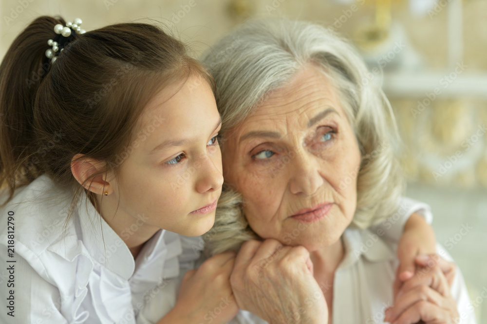 Portrait of a sad grandmother and granddaughter hugging Portrait of a sad grandmother and granddaughter hugging