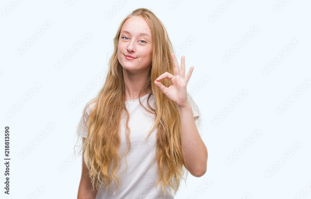 Blonde teenager woman doing ok sign with fingers, excellent symbol Blonde teenager woman doing ok sign with fingers, excellent symbol
