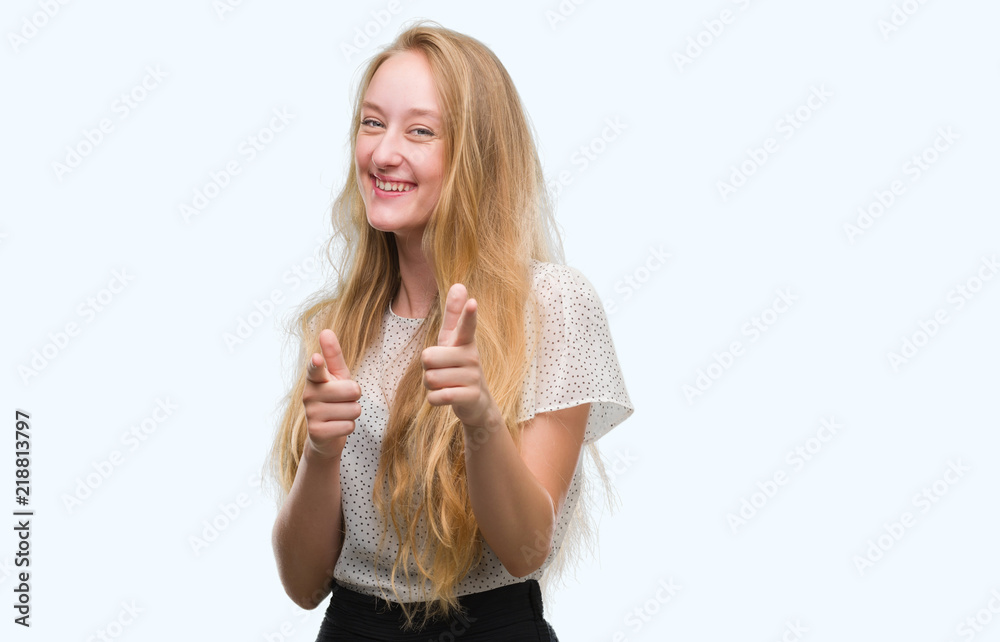 Blonde teenager woman wearing moles shirt pointing fingers to camera with happy and funny face. Good energy and vibes. Blonde teenager woman wearing moles shirt pointing fingers to camera with happy and funny face. Good energy and vibes.