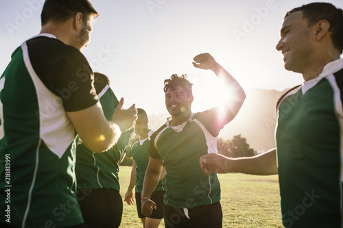 Rugby team rejoicing victory on sports field