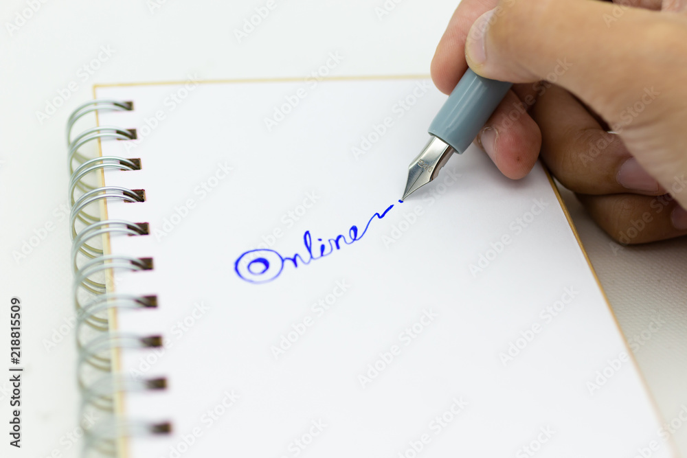 Hand holding pen and write text 'online'. Image use for network, internet, business concept. Hand holding pen and write text 'online'. Image use for network, internet, business concept.