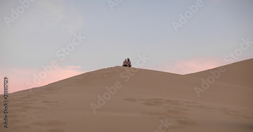 guy and girl on a sand dune