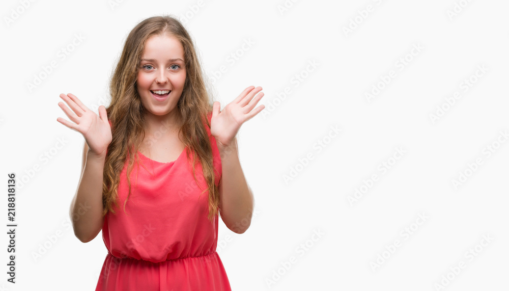 Young blonde woman wearing pink dress very happy and excited, winner expression celebrating victory screaming with big smile and raised hands