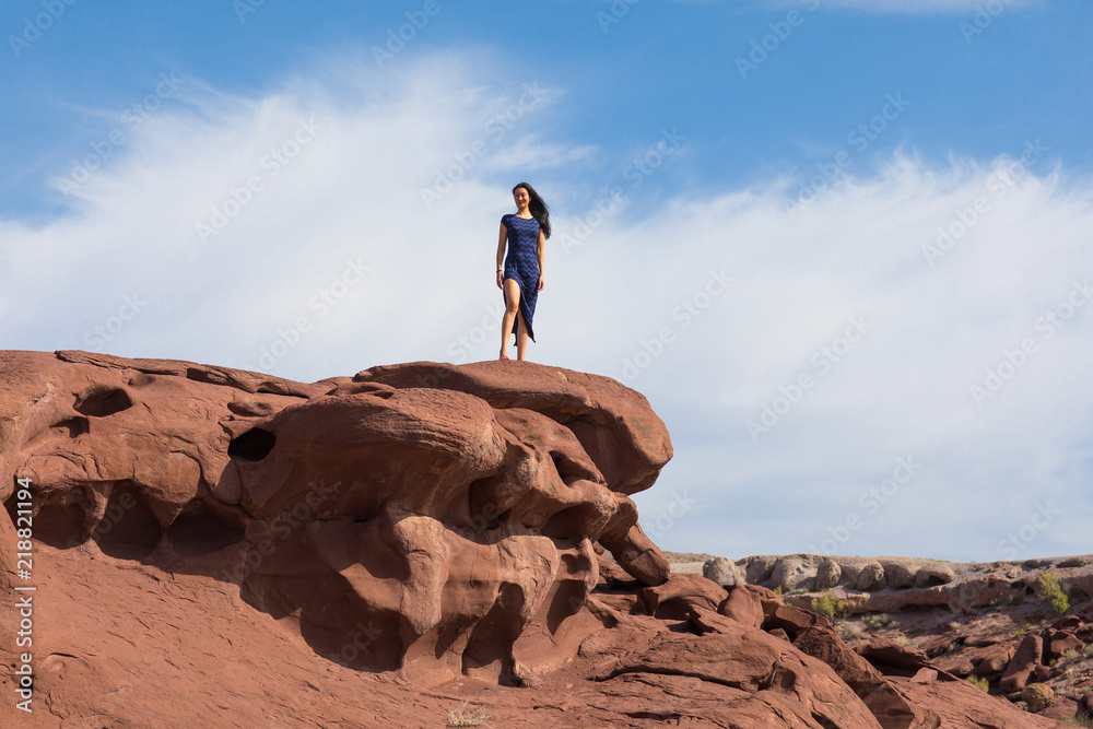 young woman in a black dress on top of a mountain