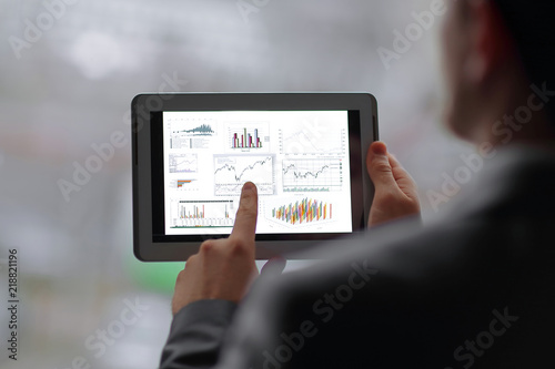 close up. businessman is analyzing financial report using digital tablet