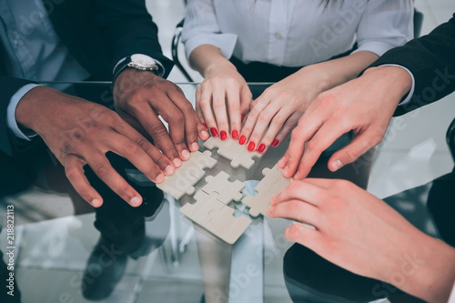 closeup. business team with puzzle pieces behind a Desk