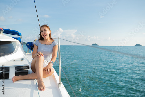 Lifestyle series: Asian woman relaxing on catamaran yacht