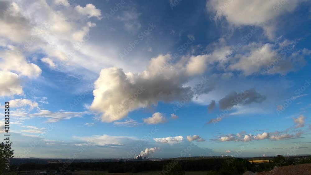 Timelapse of power plant on the horizon as well as a wind farm Timelapse of power plant on the horizon as well as a wind farm