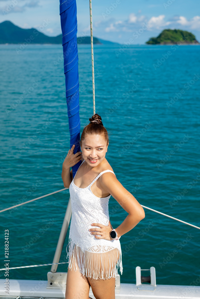 Lifestyle series: Asian woman relaxing on catamaran yacht Lifestyle series: Asian woman relaxing on catamaran yacht