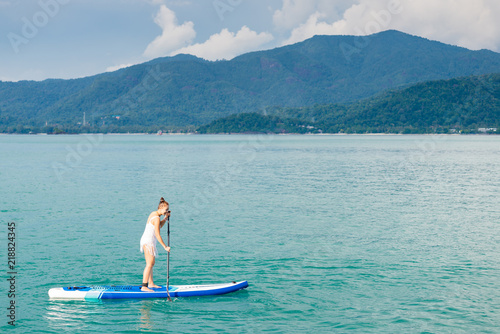 Sea series: Asian woman paddling SUP board in the sea