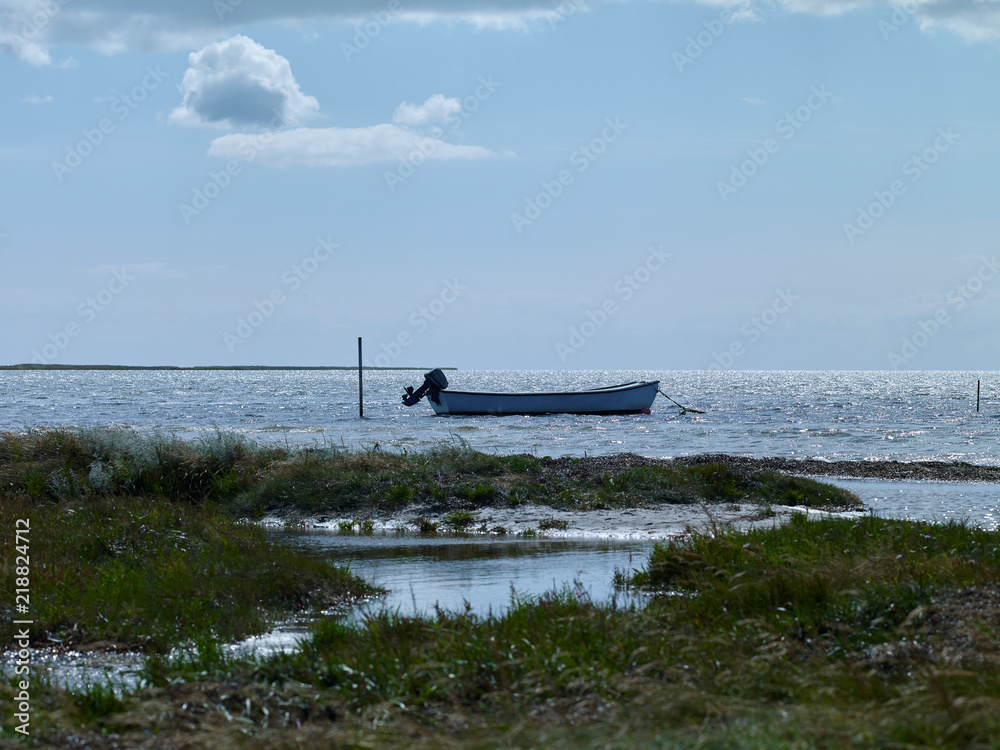Laesoe / Denmark: Small fishing boat anchoring in the wide bay at Bloeden Hale