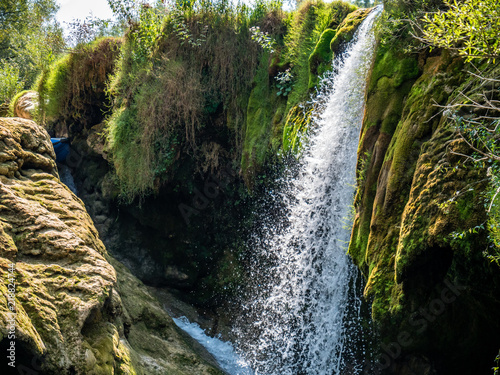 Waterfall on river Mrežnica in Croatia with a rafting boat visible