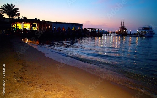 Sunset over Red Sea at Hurghada. Sun, Palm trees, light and boats.