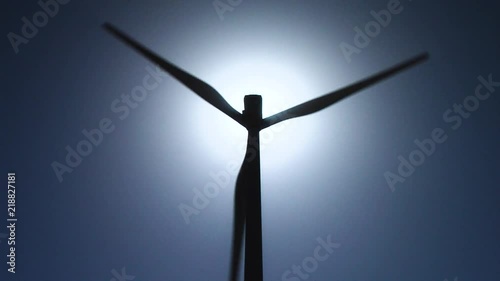 Zoom IN and OUT of a Wind turbine silhouette with sun in backlight. Unlimited renewable energy. photo