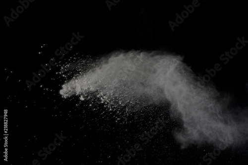 White powder explosion isolated on black background. Colored dust splatted.