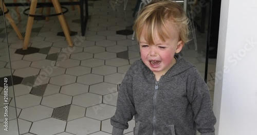 Children's hysteria in the cafe. Cute little Caucasian boy crying close up