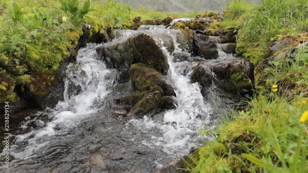 A picturesque waterfall in the mountains of the Subpolar Urals. Falling water in a mountain river A picturesque waterfall in the mountains of the Subpolar Urals. Falling water in a mountain river