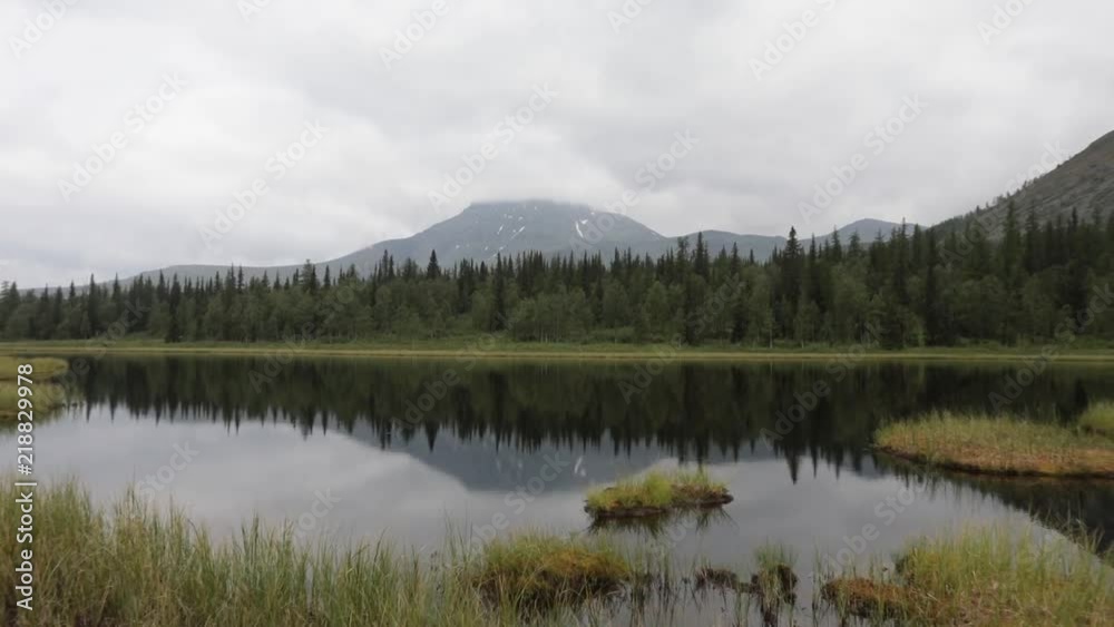 Quiet tranquil mountain lake. Reflection of green peaks in water Quiet tranquil mountain lake. Reflection of green peaks in water