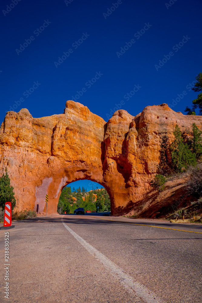 Scenic view of stunning red sandstone natural bridge and asphalt road in Bryce Canyon National Park in Utah Scenic view of stunning red sandstone natural bridge and asphalt road in Bryce Canyon National Park in Utah