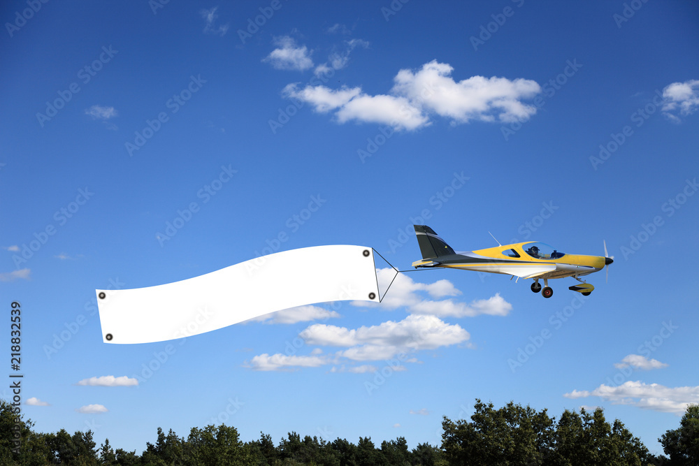 Piękny żółty samolot, awionetka nad drzewami. - obrazy, fototapety, plakaty 