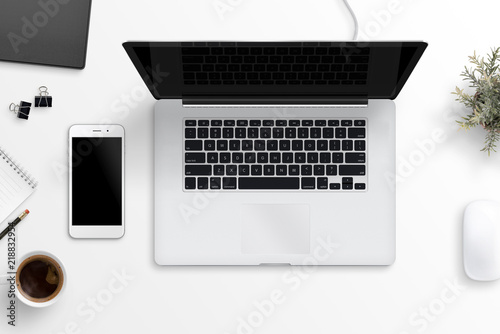 Laptop and smart phone on office desk. Blank screen for mockup, app or responsive web site design presentation. Flat lay.