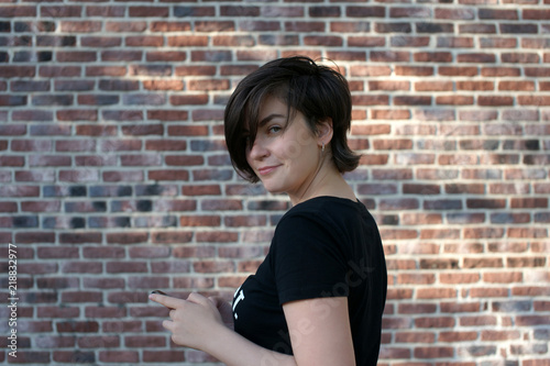 Portrait of a young woman on a brick wall background