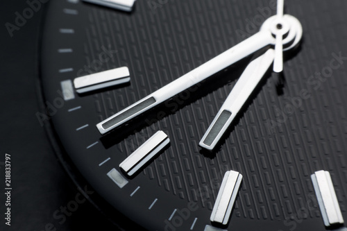 Close up clockwise on black clock face background. Wristwatch in retro style