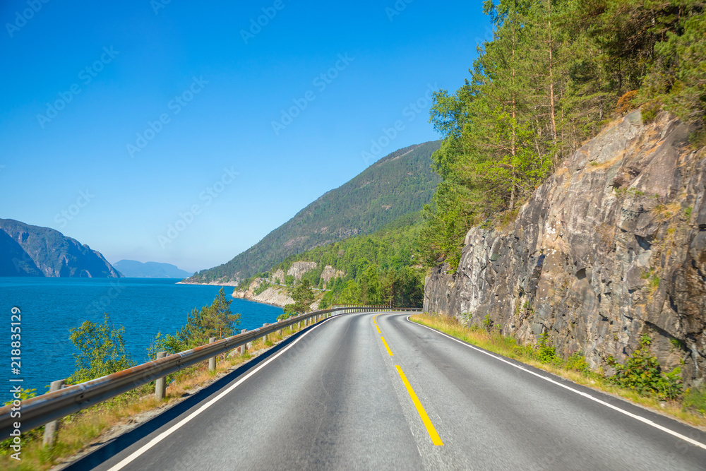 Scenic mountain road next to fjord in summer day in Norway