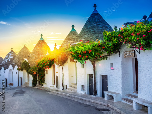Fotografija Traditional Trulli houses in Alberobello village, illuminated at sunrise in Bari region of Italy