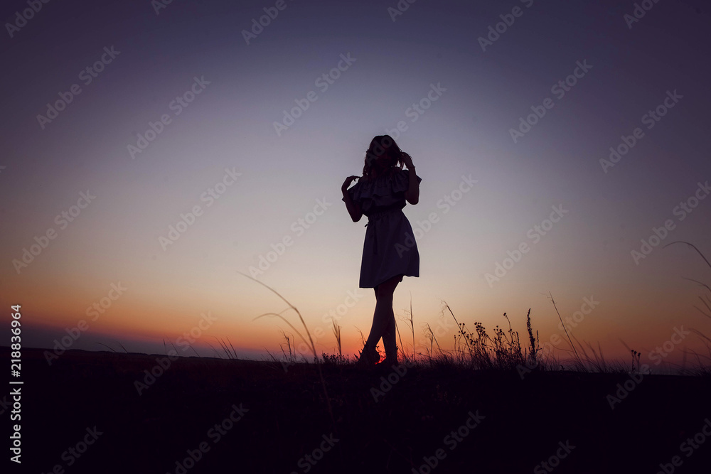 Woman going to sunset in the field