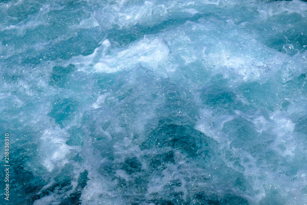 Troubled blue sea water with white foam, abstract nature background concept