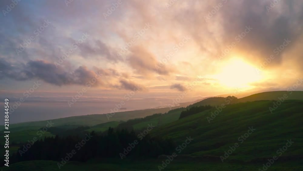 Green field on hill with small pieces of forest during Colorful Sunrise Green field on hill with small pieces of forest during Colorful Sunrise