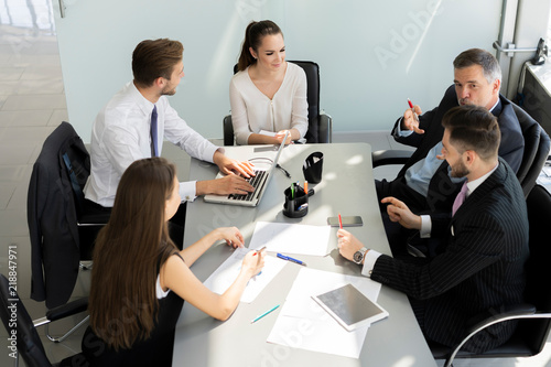 Businesspeople discussing together in conference room during meeting at office.