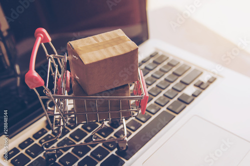 Shopping online. cardboard box with a shopping cart logo in a trolley on laptop keyboard. Shopping service on The online web. offers home delivery