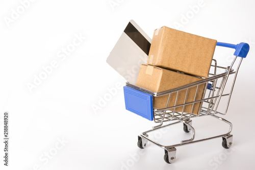 Shopping concept : Cartons or Paper boxes and credit card in blue shopping cart on white background. online shopping consumers can shop from home and delivery service. with copy space