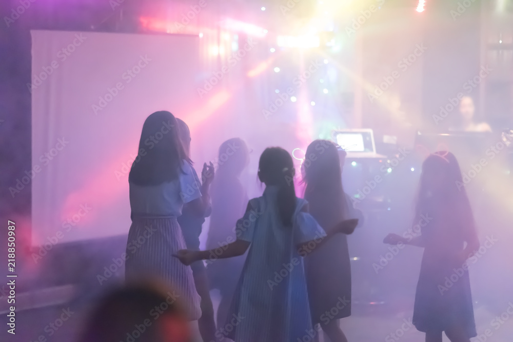 Naklejka premium blur Light in club party Show And Silhouette hands of audience crowd people use smart phones enjoying the club party with concert. Blurry night club DJ party people enjoy of music dancing sound.